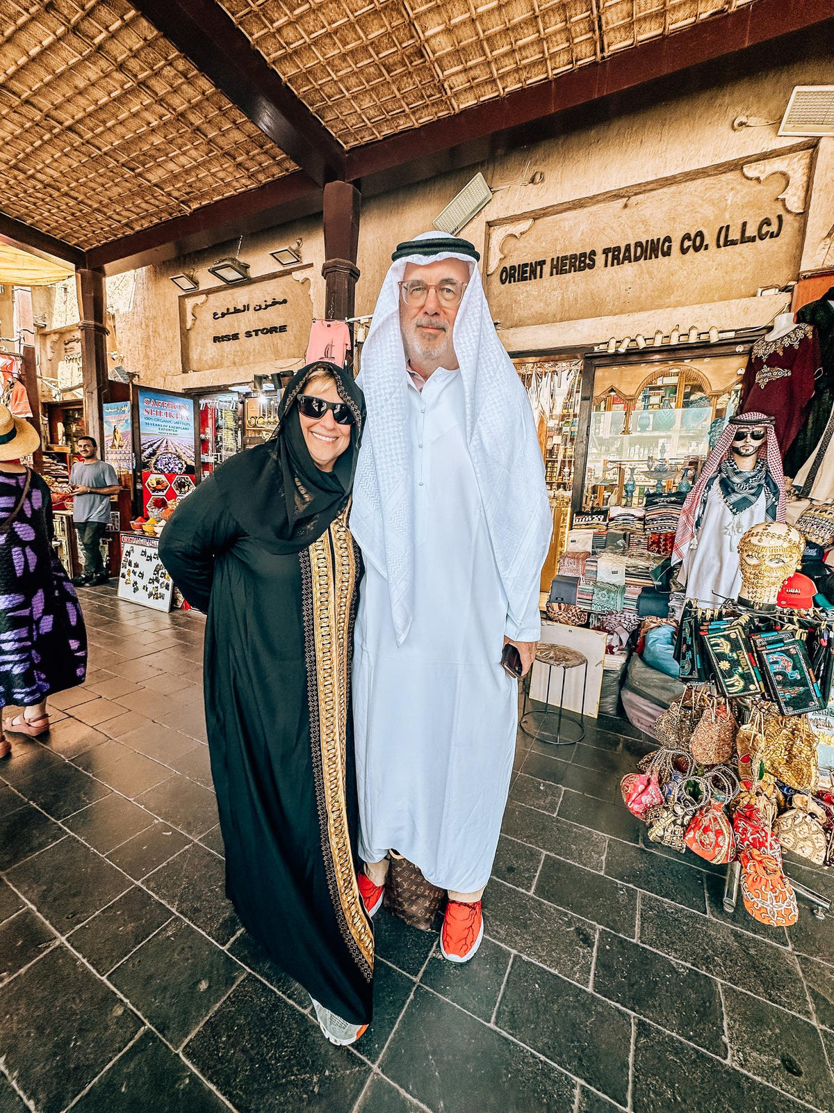Visiting parents dressed in an abaya and kandura in a Deira souk on the Dubai Parents' Day Out Tour