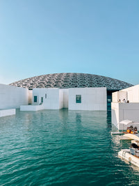 The dome of Louvre Abu Dhabi rising over the water on Saadiyat Island, the first stop of the Abu Dhabi Cultural Tour