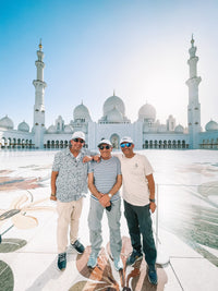 Three guests in the marble courtyard of Sheikh Zayed Grand Mosque at the end of the Abu Dhabi Cultural Tour