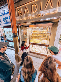 Nada Badran explaining the Gold Souk to tour guests outside a jewellery window in Deira, Old Dubai