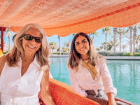 Two guests smiling on an abra along the canals of Madinat Jumeirah at the end of the day