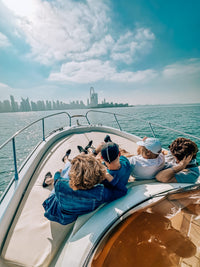 Guests relaxing on the bow during the private Dubai Marina cruise, with the Dubai skyline ahead