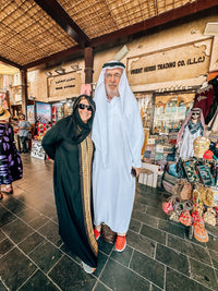 Visiting parents dressed in an abaya and kandura in a Deira souk on the Dubai Parents' Day Out Tour