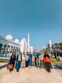 A group of visitors outside Sheikh Zayed Grand Mosque on a guided tour from Dubai